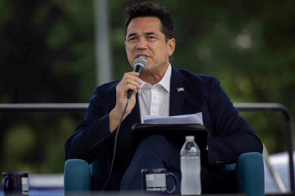 Dean Cain speaking into a microphone.