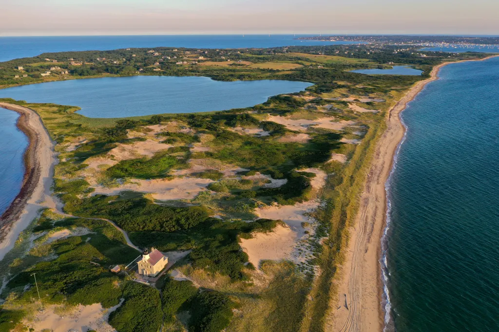 Aerial view of the North Lighthouse on Block Island, Rhode Island, with sand dunes, beach, and ocean.