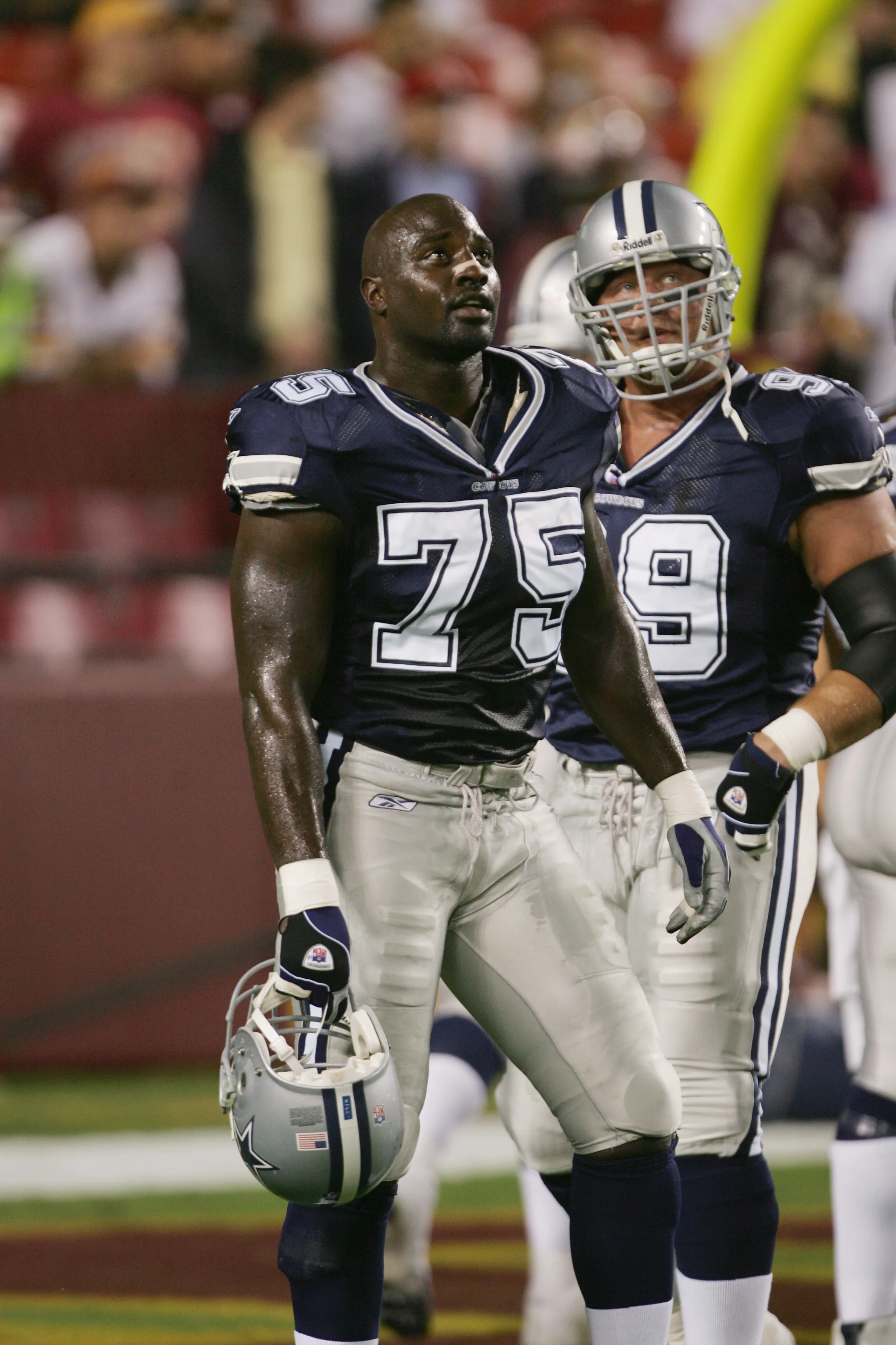 Defensive end Marcellus Wiley #75 of the Dallas Cowboys holding his helmet on the sideline.