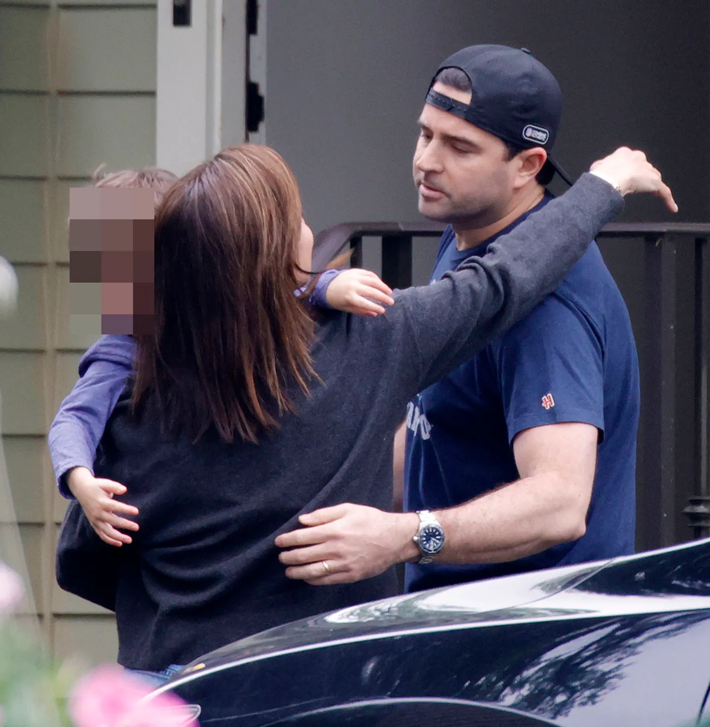 Dianna Russini greeting her husband Kevin Goldschmidt and one of their children with a hug.