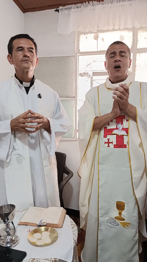 Two men in religious vestments participating in what appears to be a Mass.