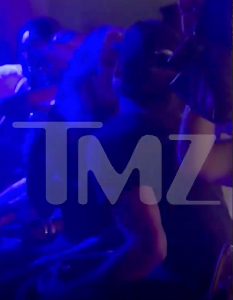 Dylan Wolf and Bunnie XO kissing, illuminated by blue light with a TMZ watermark.