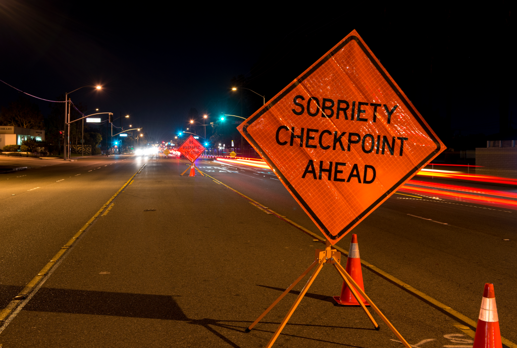 A "Sobriety Checkpoint Ahead" sign on a highway at night in Anaheim, California.
