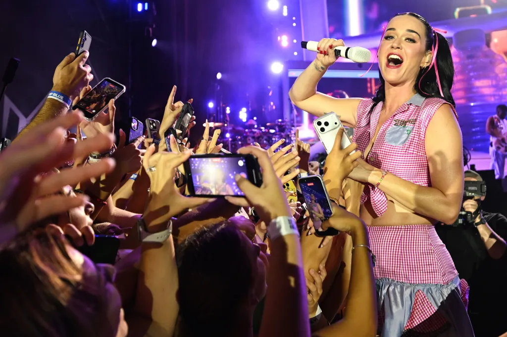 Katy Perry performing at the Isle of MTV Malta 2026, with audience members holding up phones to record.