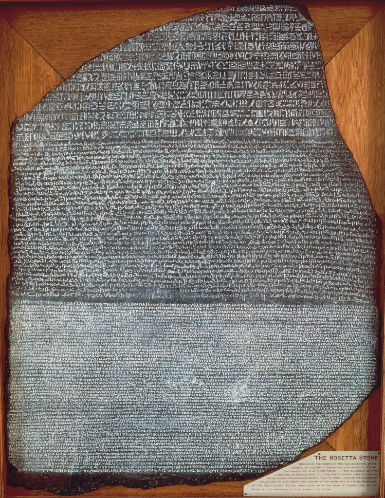 The Rosetta Stone, a dark granite tablet, with inscriptions in Egyptian hieroglyphs, Egyptian demotic script, and Greek.