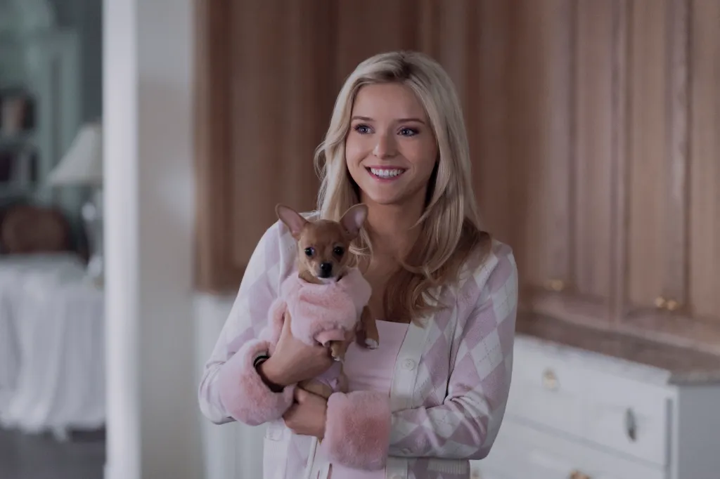 Lexi Minetree as Elle Woods, holding a chihuahua dressed in pink.