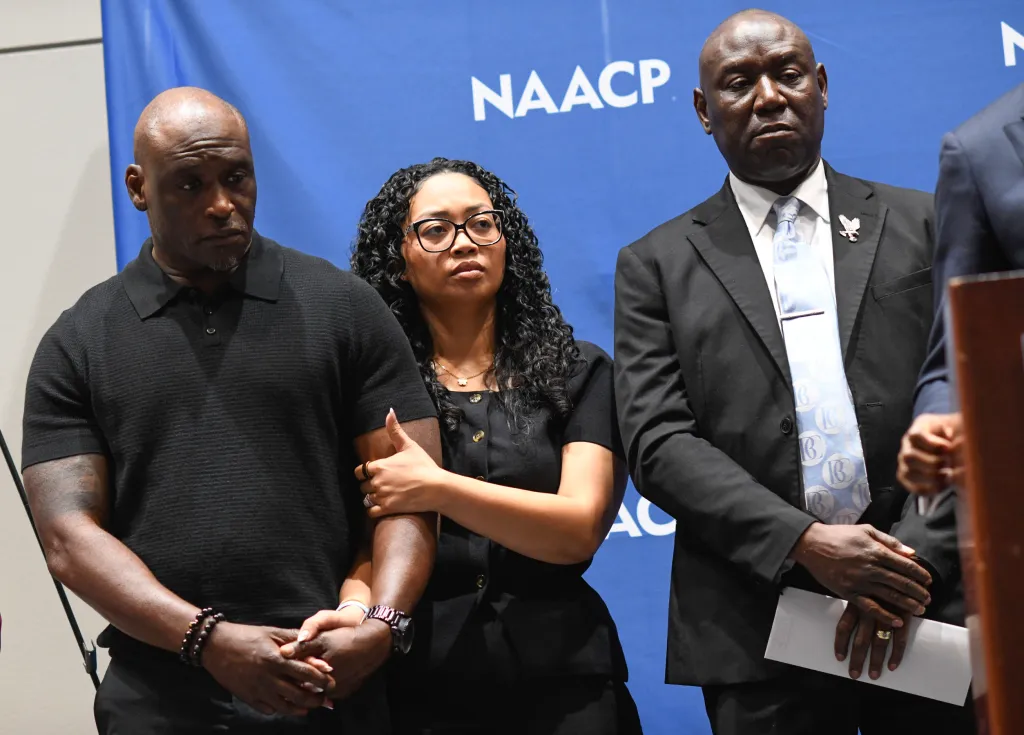 The parents of Nolan Xavier Wells, Elmore and Christine Wonsley, stand with civil rights attorney Ben Crump at a news conference.