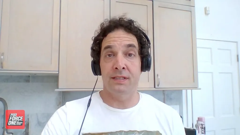 Alex Berenson with headphones on talking to the camera.