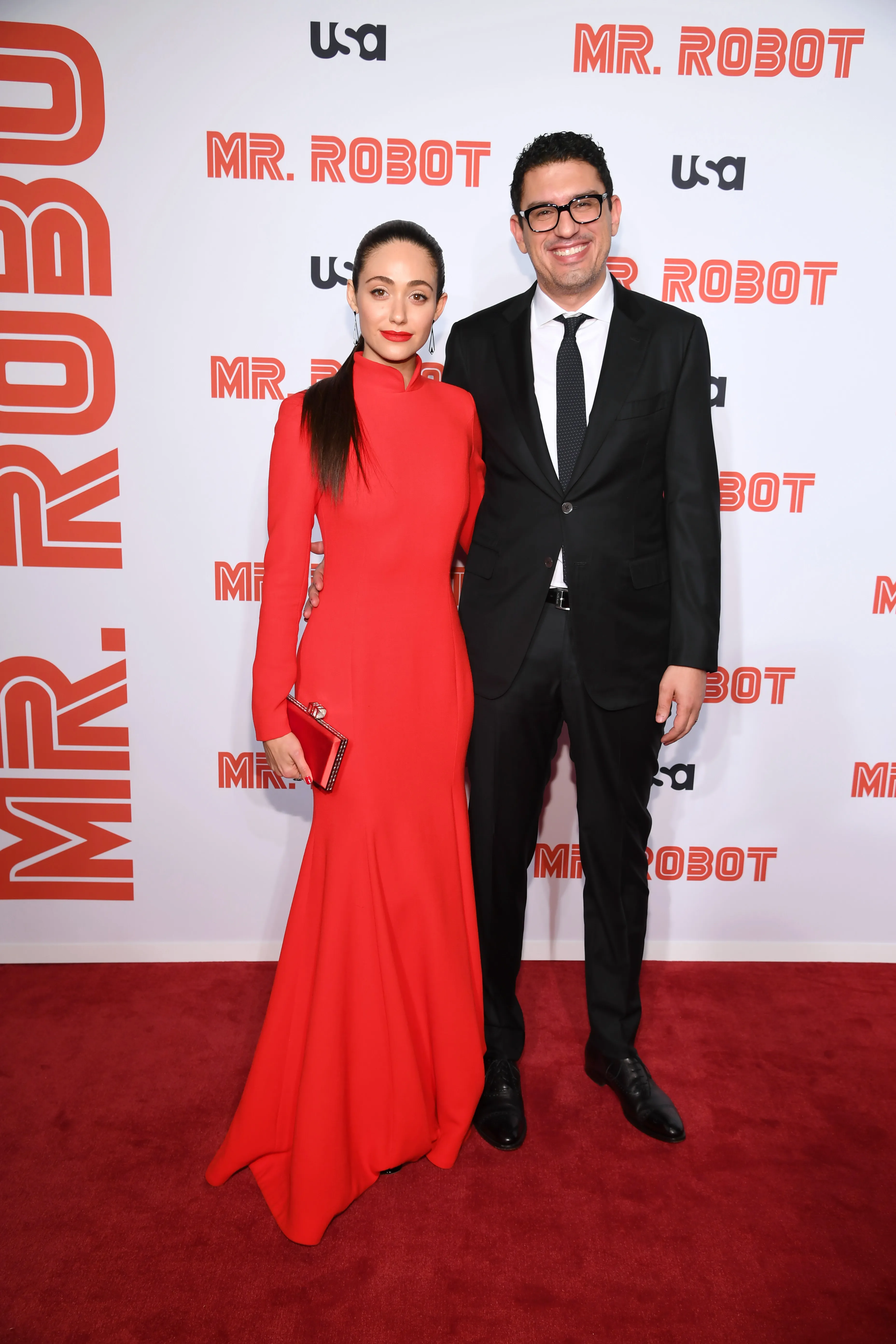Emmy Rossum in a red gown and Sam Esmail in a suit on the red carpet for the "Mr. Robot" Season 4 Premiere.