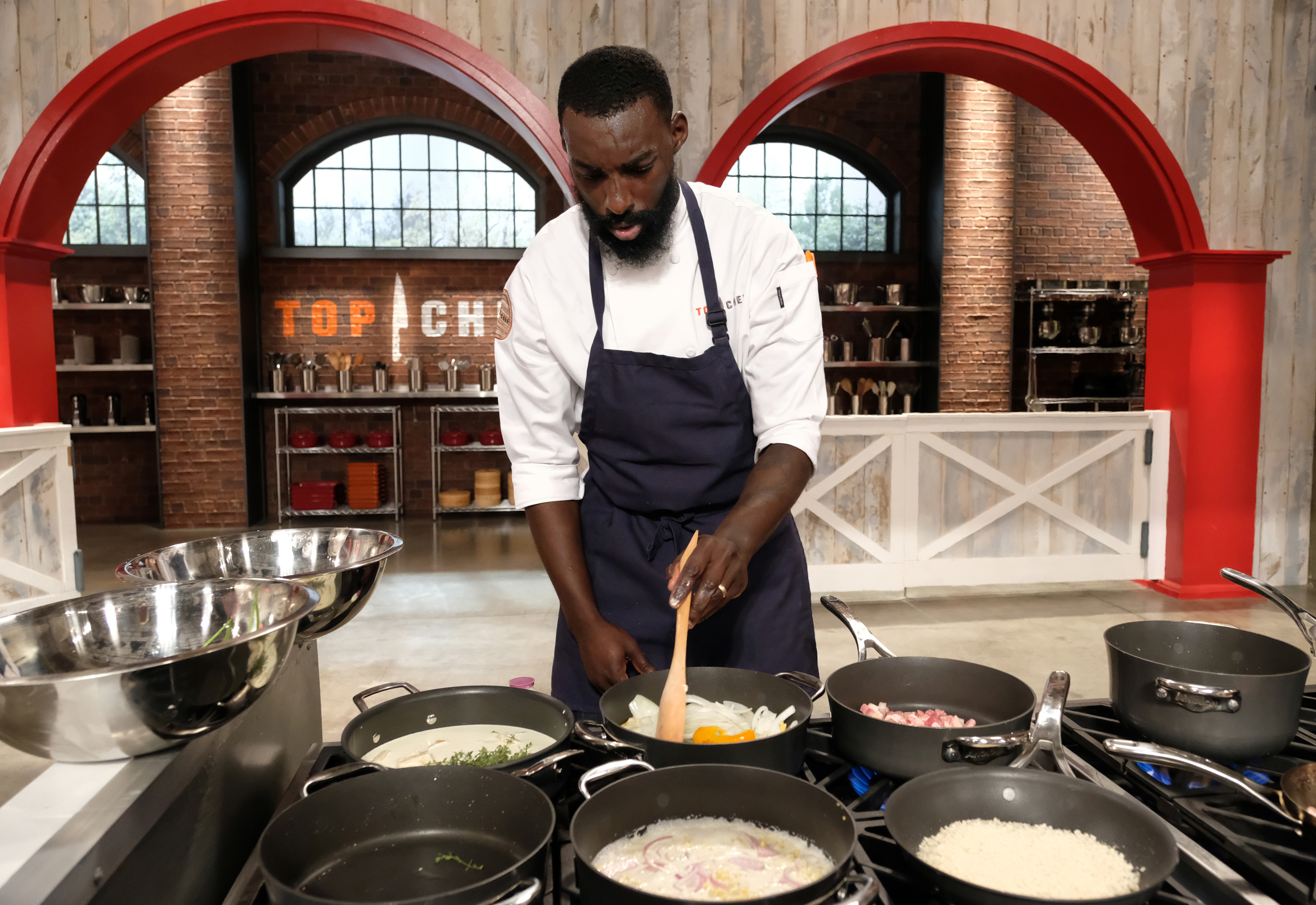 Eric Adjepong cooking in a kitchen on the set of Top Chef.
