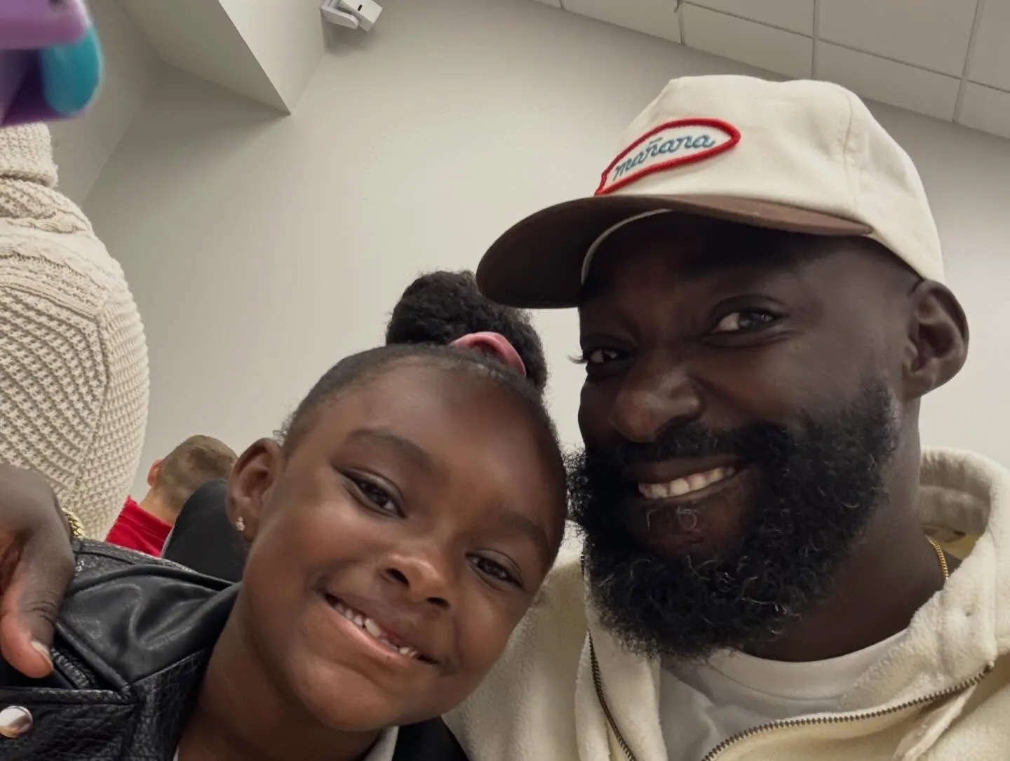 Eric Adjepong and his daughter smiling at the camera.