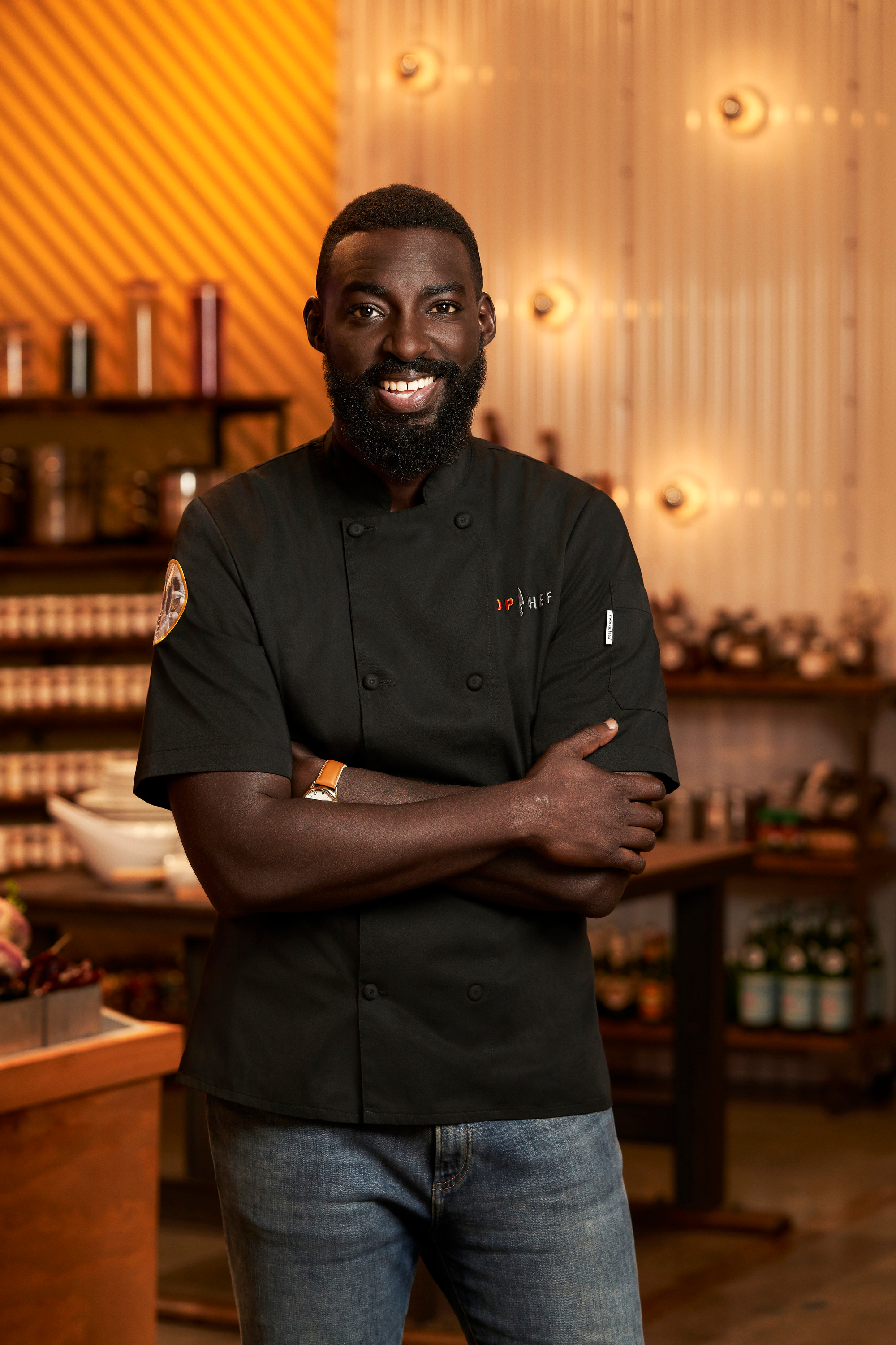 Eric Adjepong smiling with his arms crossed.