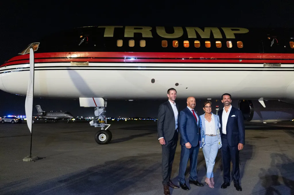 Eric Trump, Joseph Abruzzo, Maria Marino, and Donald Trump Jr. pose for a photo in front of "Trump Force One".