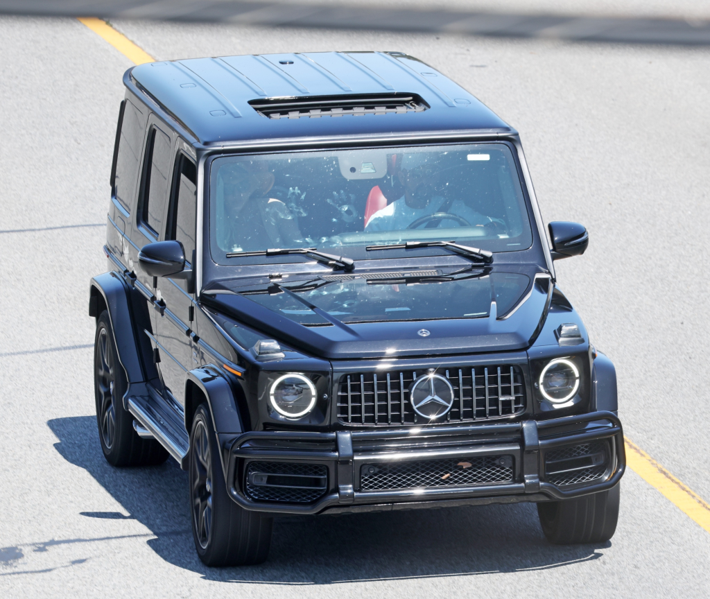 Britney Spears in the passenger seat of a black Mercedes G Wagon.