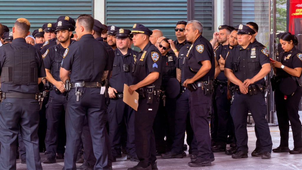 A group of NYPD and National Guard officers holding a security meeting outside Madison Square Garden.