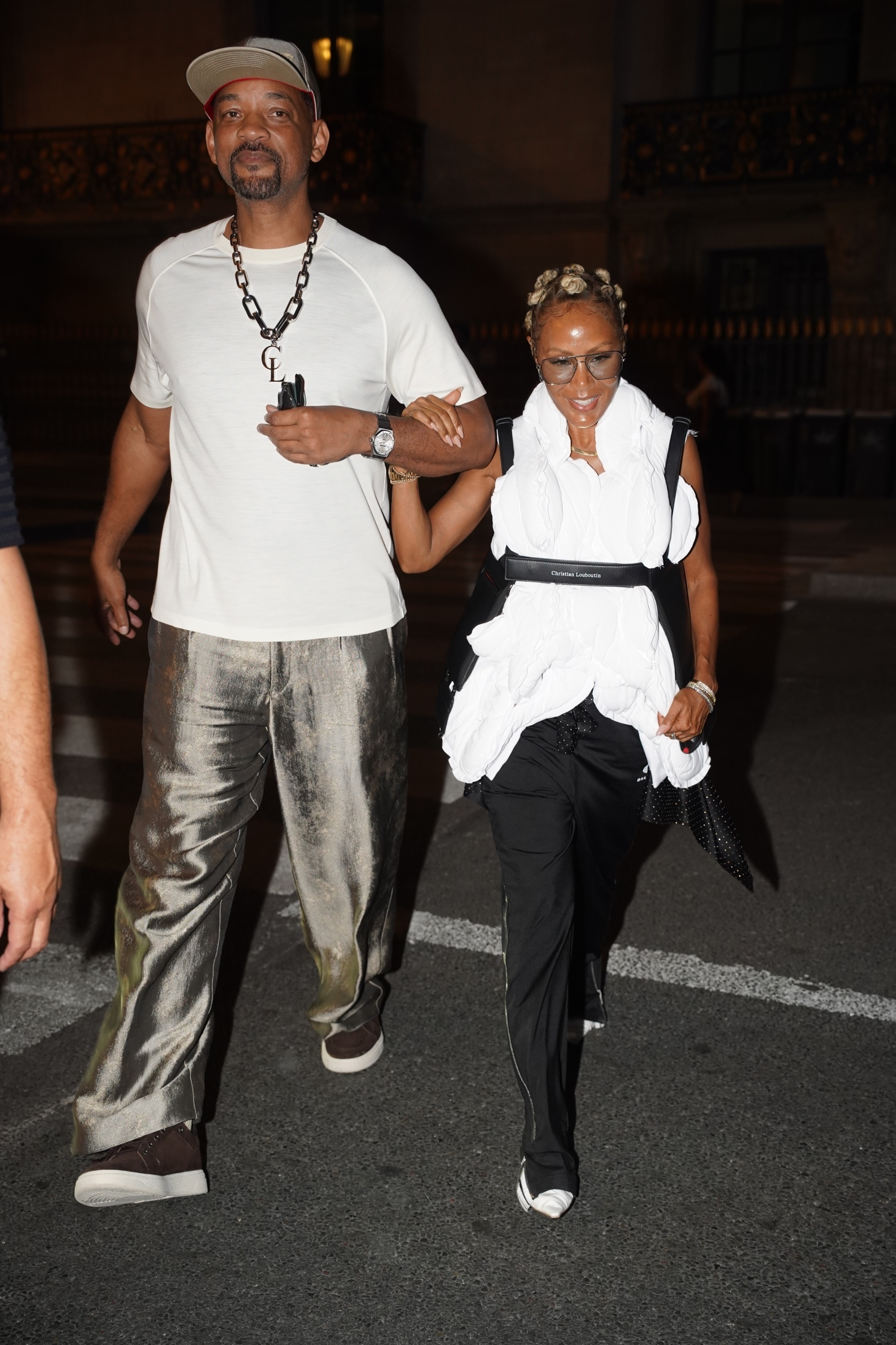 Will Smith and Jada Pinkett Smith arm-in-arm walking together.