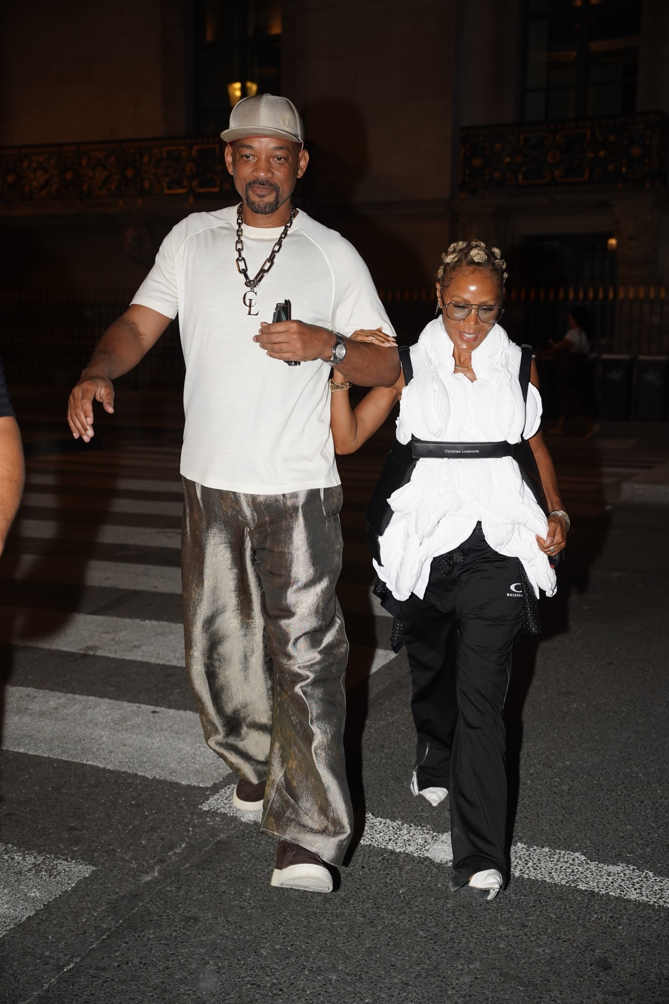 Will Smith and Jada Pinkett Smith walk arm-in-arm down a city street at night.
