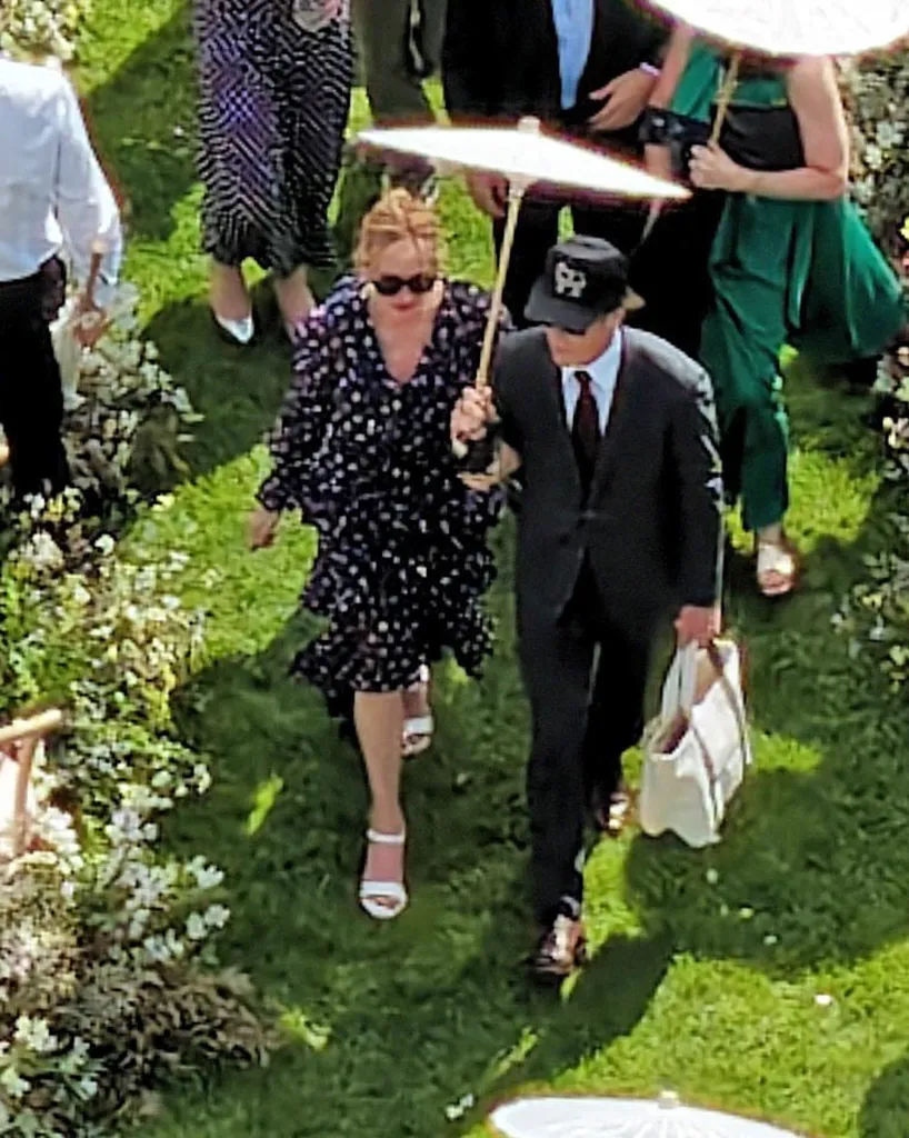 Julia Roberts and Daniel Moder walking outdoors with an umbrella.