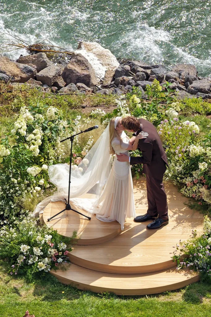 Emma Roberts and Cody John kiss at their wedding ceremony next to a river.