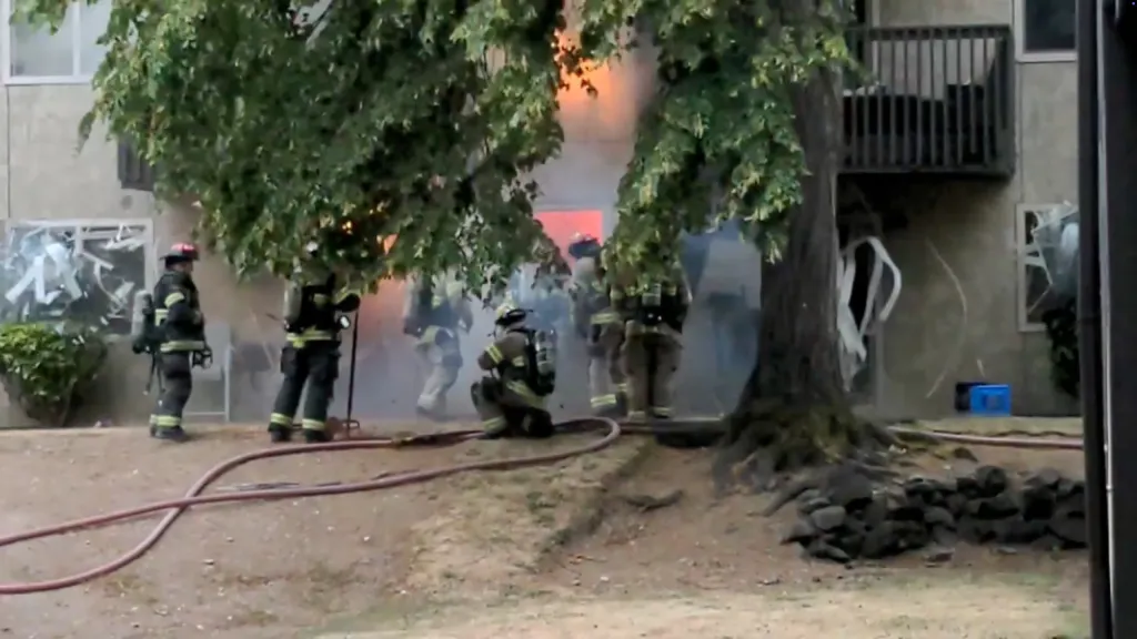Firefighters near a building with an explosion in an electrical room.