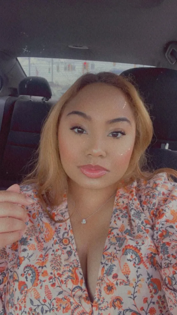 Selena Ponce in a car, looking at the camera.
