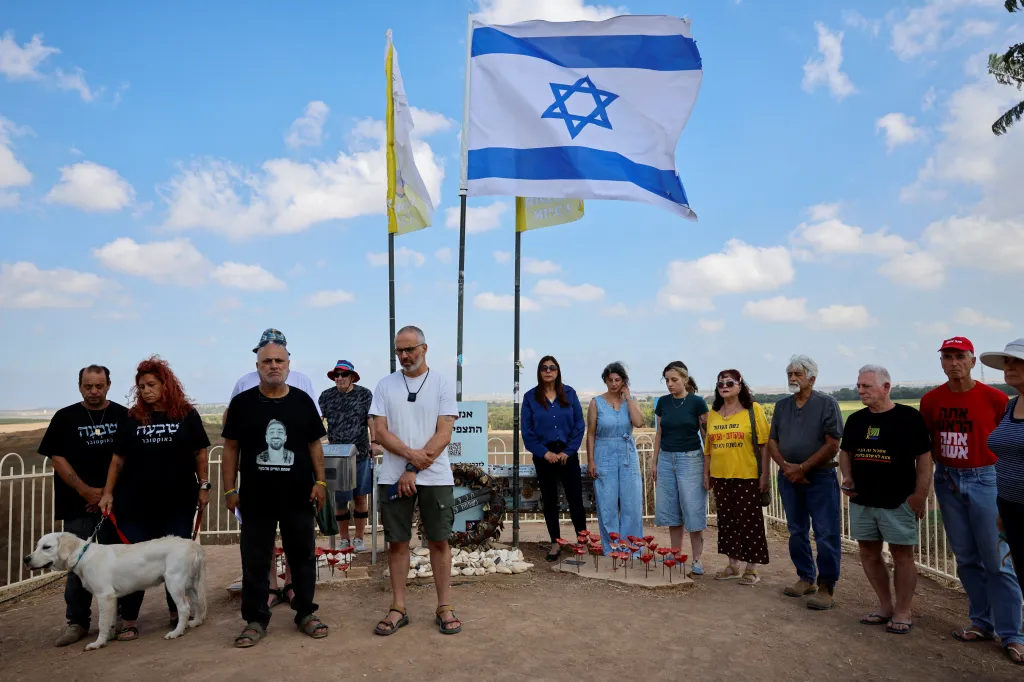 Family members and loved ones stand for a moment of silence for the victims of the October 7, 2023 attack near Nir Oz.