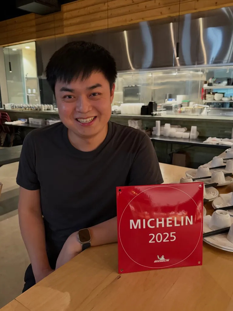 Restaurateur You You Xue smiling with a Michelin 2025 plaque.