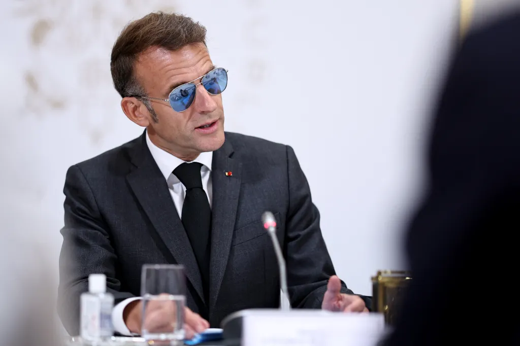 Emmanuel Macron wearing aviator sunglasses at a meeting.