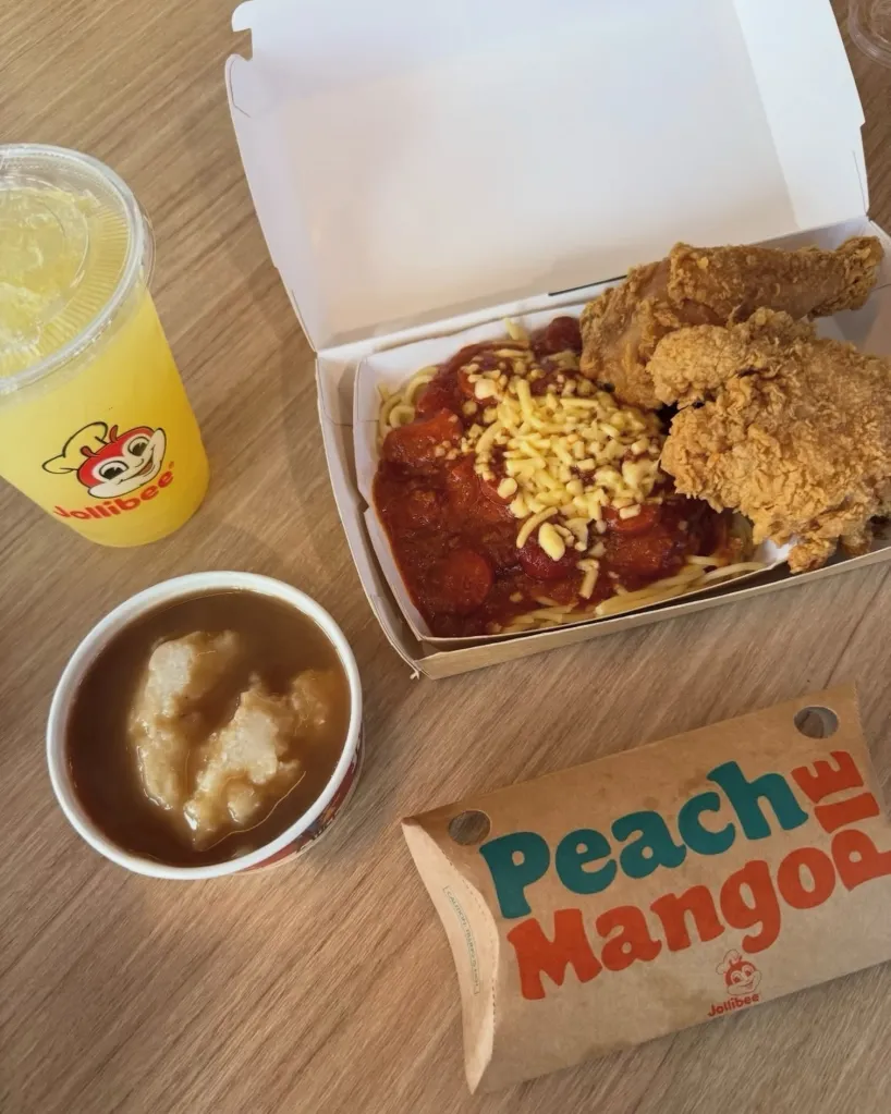 Jollibee meal including fried chicken, spaghetti, mashed potatoes, a peach mango pie, and a drink.