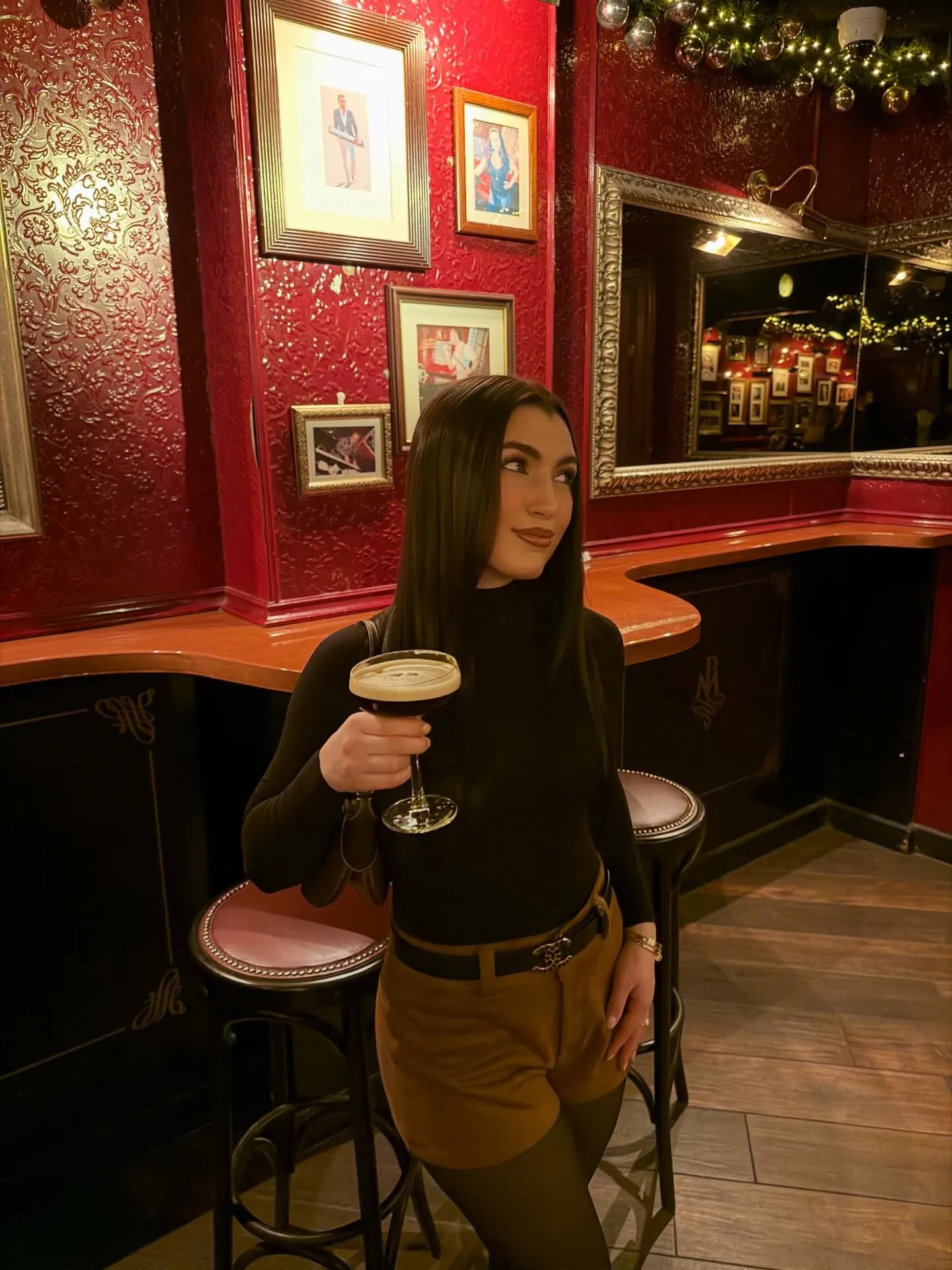 Gabriella Giudice holding a drink in a dimly lit bar.