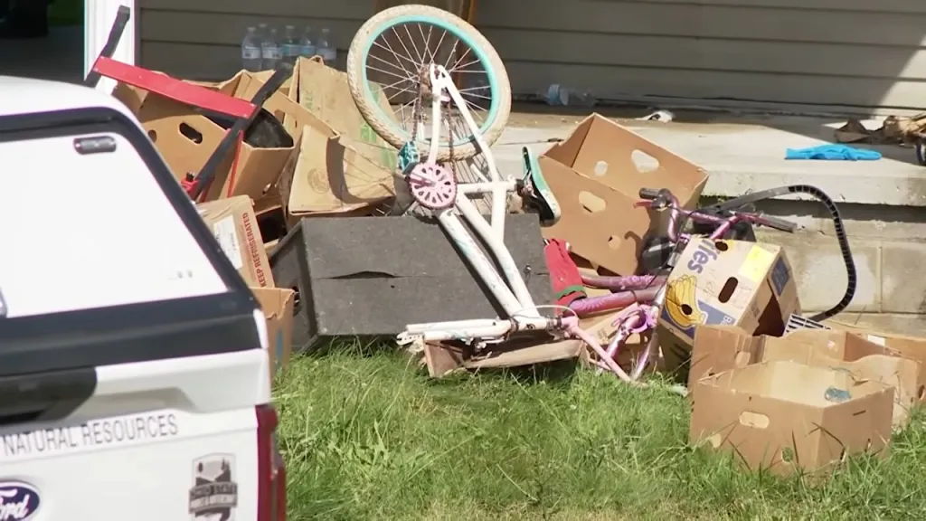Children's bikes and cardboard boxes piled on the grass and next to the Vinton County, Ohio, home where authorities allege 16 kids were kept in horrific conditions