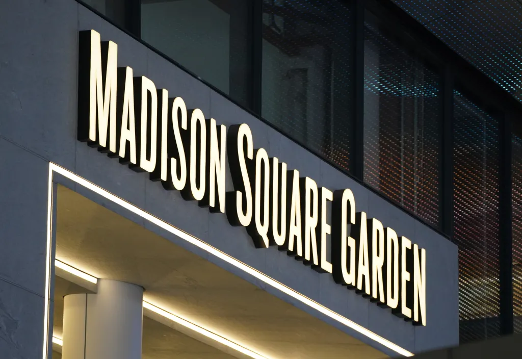 A close-up of the illuminated "Madison Square Garden" sign on the exterior of the building.