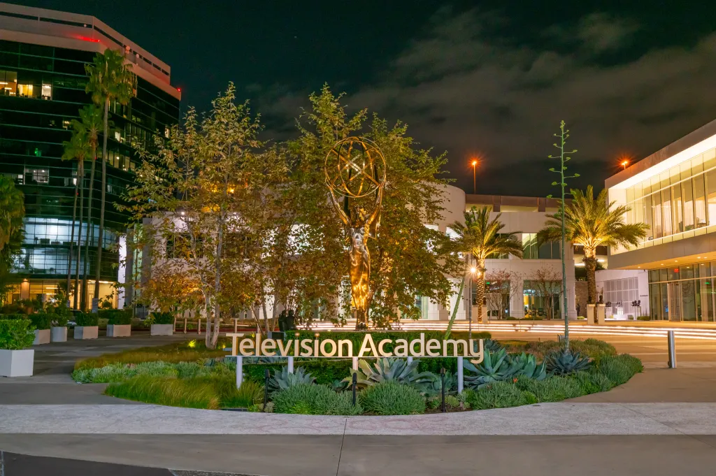 Television Academy and Saban Media Center at night, with an Emmy statue and lit trees in front of the building.