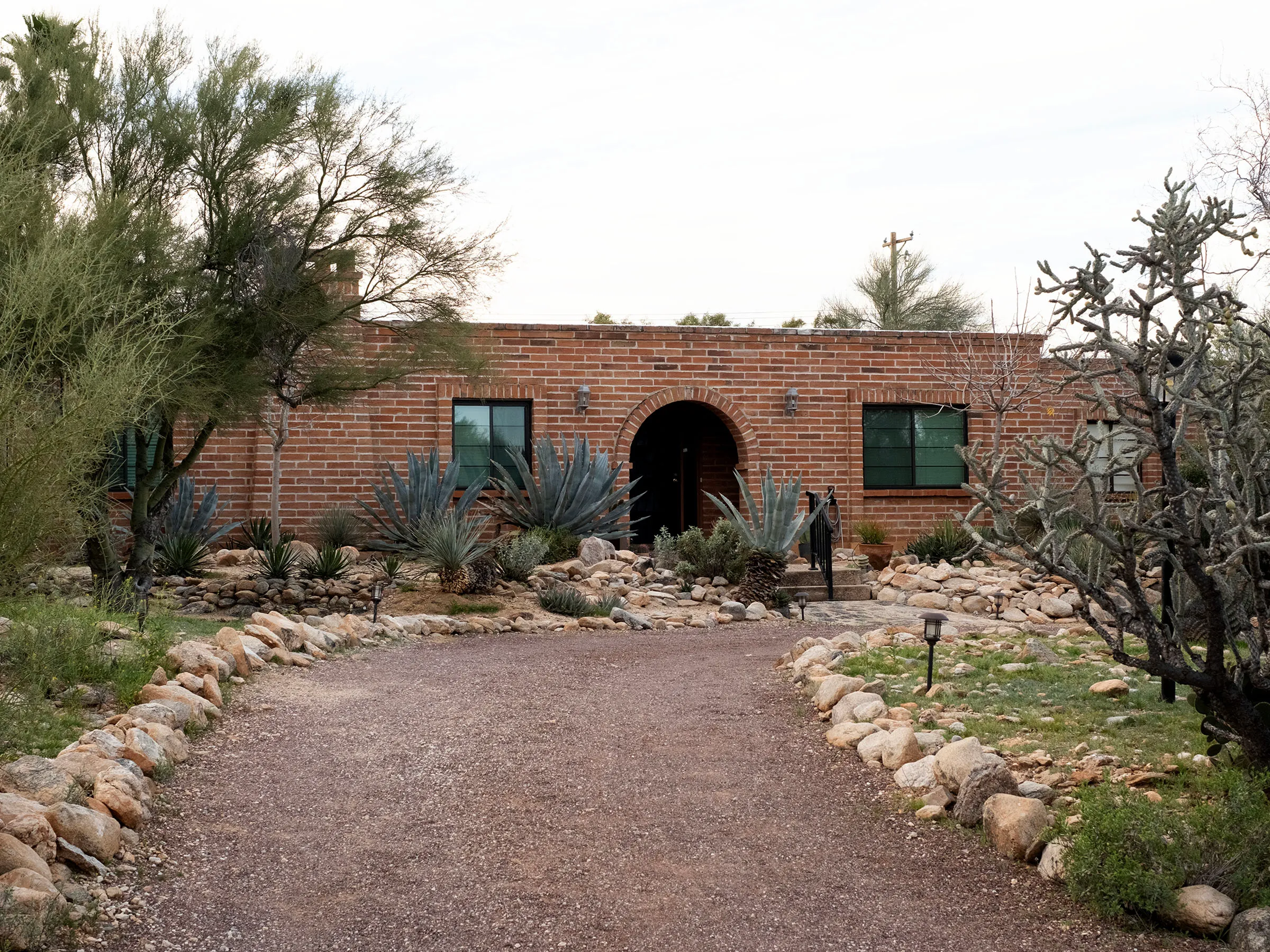 Gravel driveway leading to the brick home of Nancy Guthrie.