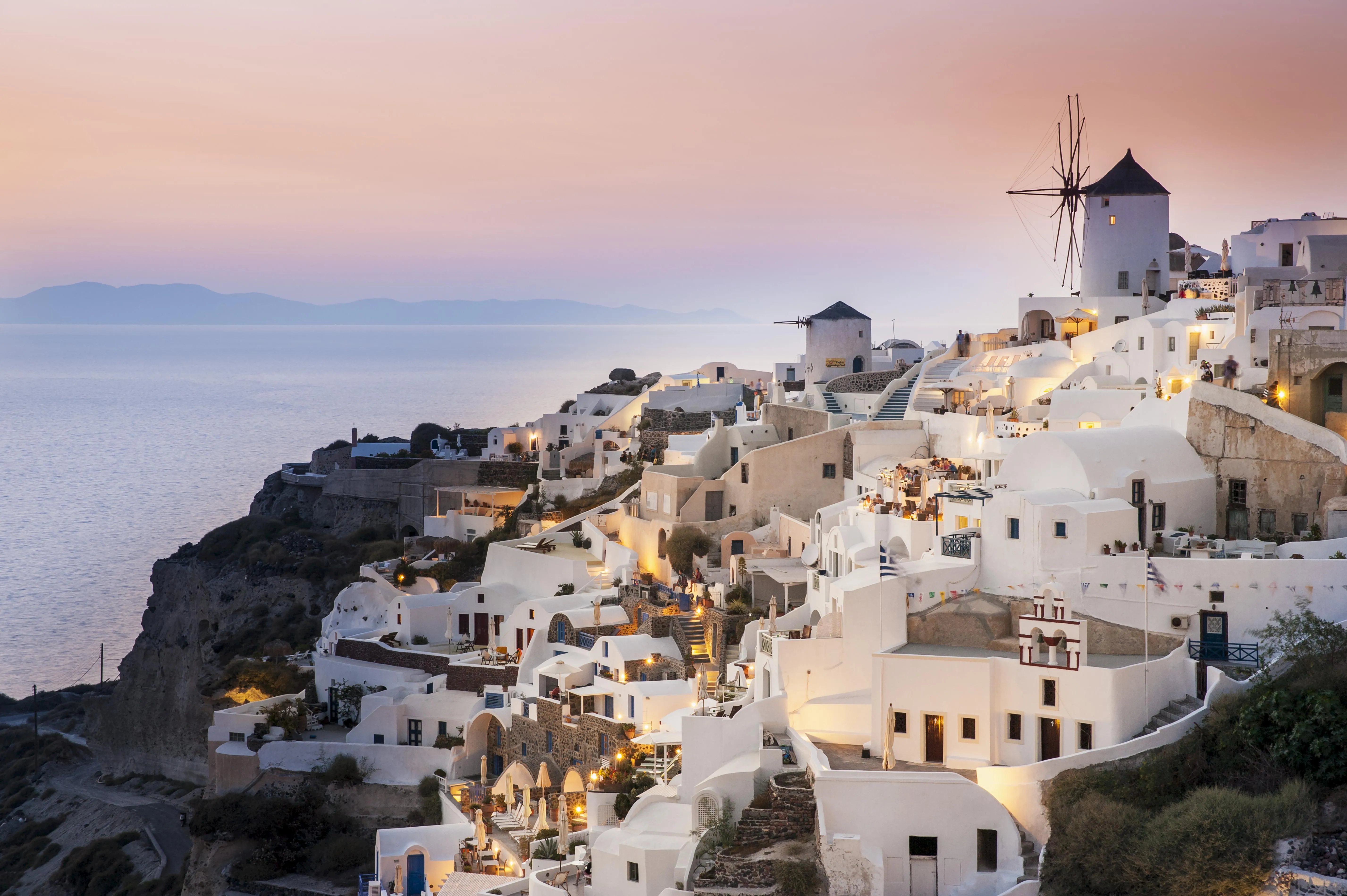 Whitewash Buildings and Windmill at Dusk. Oia, Santorini, Greece. (Photo by: Dosfotos/Design Pics Editorial/Universal Images Group via Getty Images)