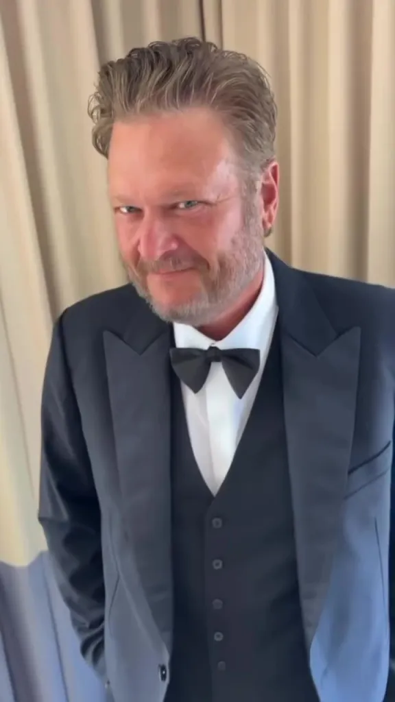 Blake Shelton in a tuxedo with a mischievous smile.