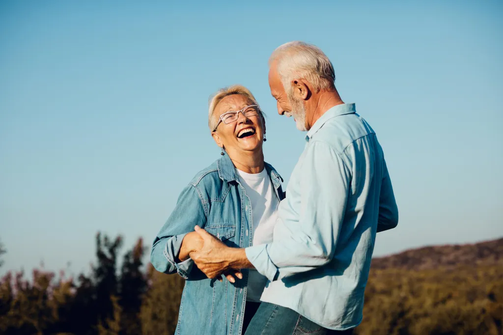 Happy senior couple laughing outdoors.
