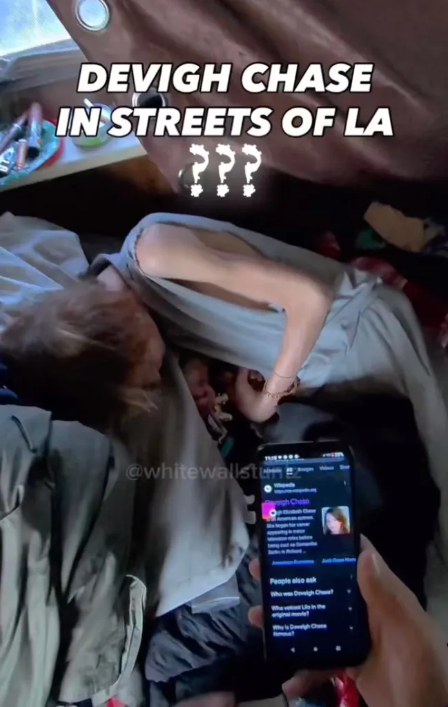 A person lying down with a phone displaying a Wikipedia search for "Daveigh Chase."