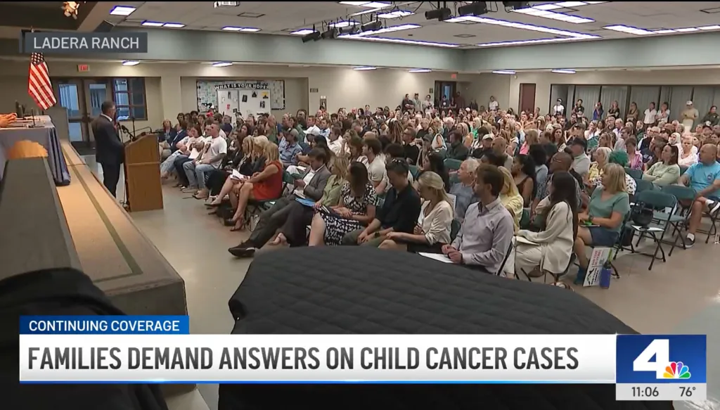A large group of people attending a public meeting to discuss childhood cancer cases in Ladera Ranch.