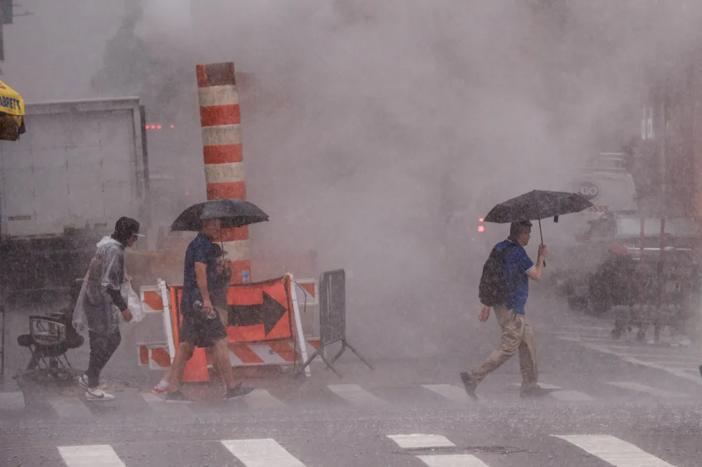 People walk through heavy rain in Times Square, New York City.