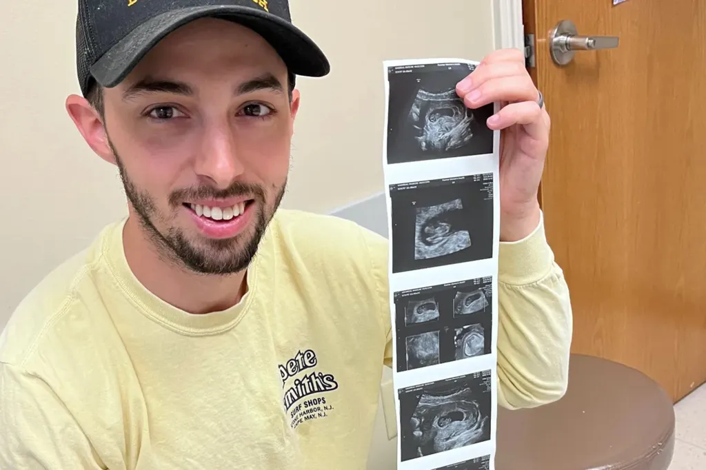 Matthew Gaudreau smiling and holding a strip of ultrasound images.