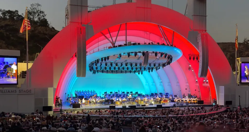 The Hollywood Bowl illuminated in red and blue during a performance.