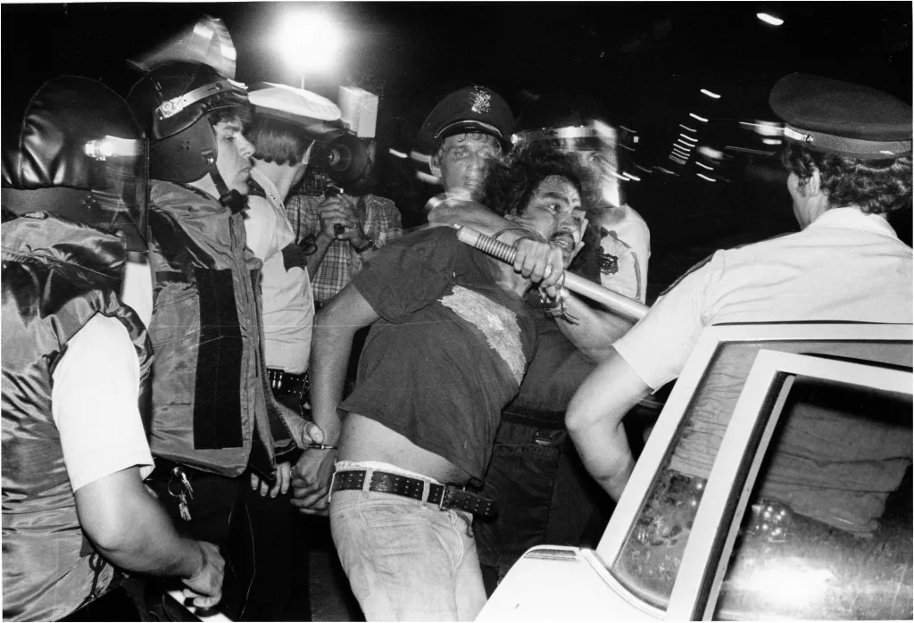 Black and white photo of Houston police taking a man into custody during the Moody Park riot.
