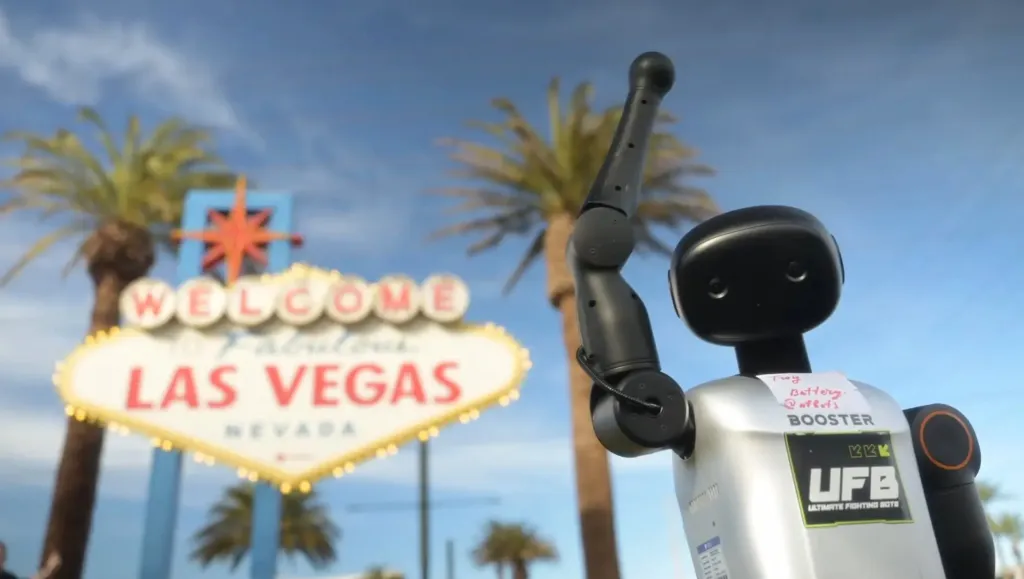 Robot raising its arm in front of the Welcome to Fabulous Las Vegas sign.