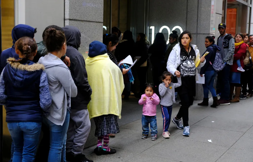 Hundreds of people stand in line outside a US immigration office in San Francisco, California.
