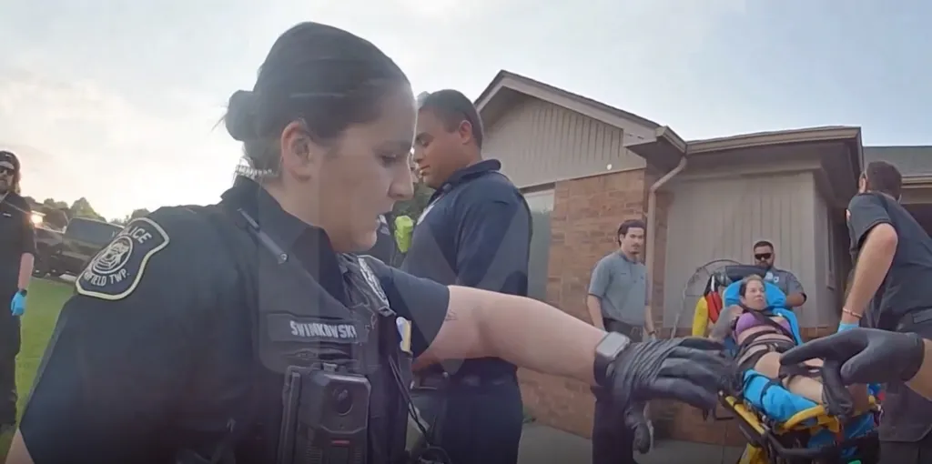 Police officers and paramedics attend to a woman on a stretcher after a suicide attempt.