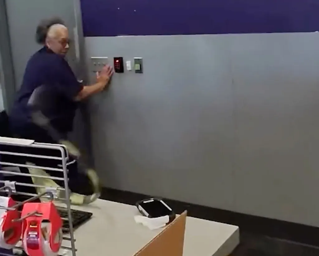 A FedEx employee startled by an iguana, lunges to the side.