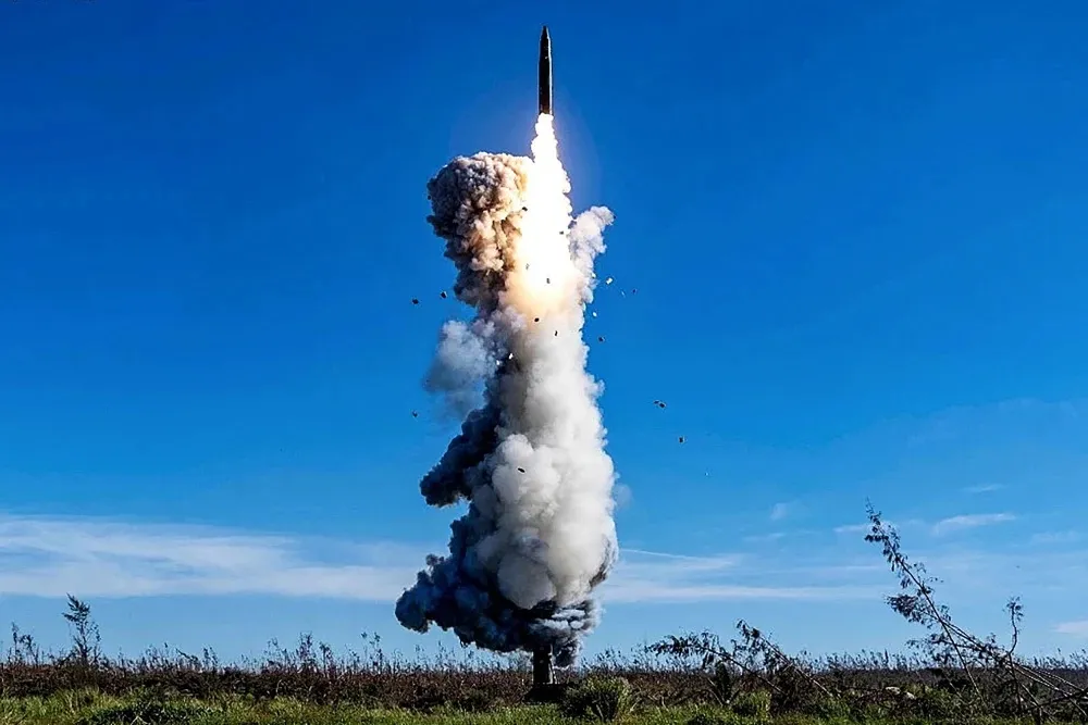 A Chinese People’s Liberation Army ICBM carrying a dummy warhead launching with a plume of white and dark smoke against a clear blue sky.