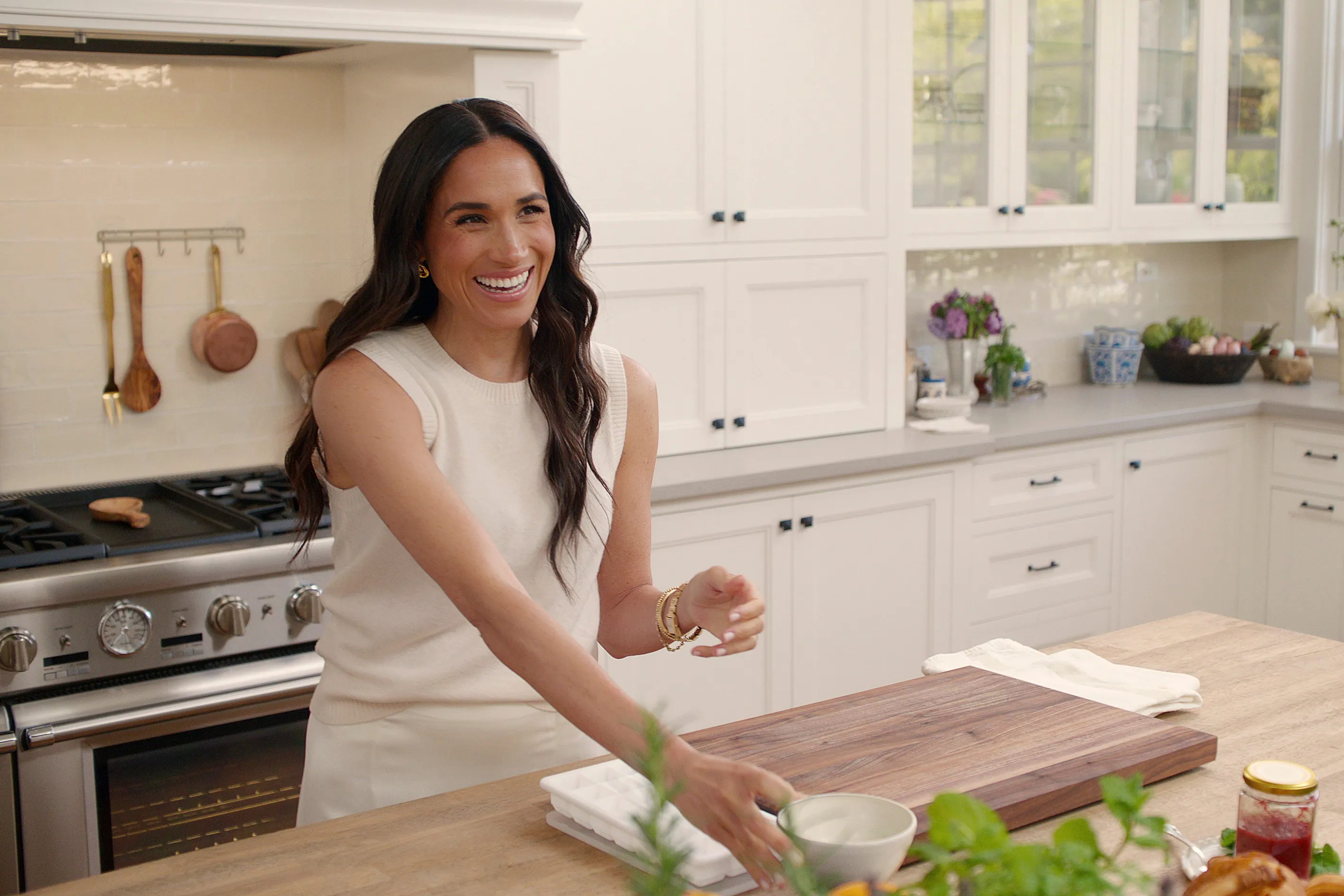 Meghan, Duchess of Sussex, smiling in a kitchen setting.