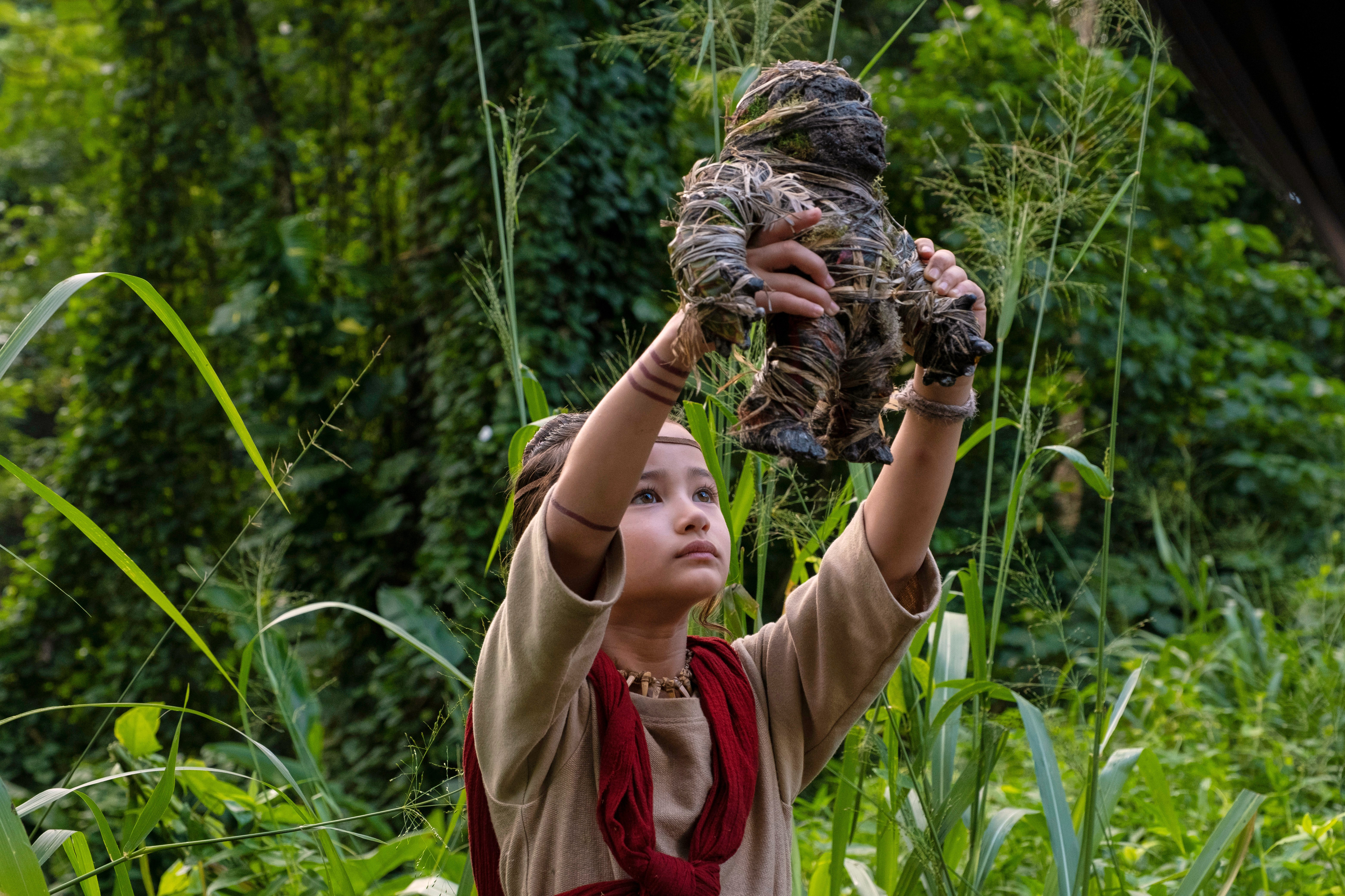 Kaylee Hottle holding up a Kong doll wrapped in straw.